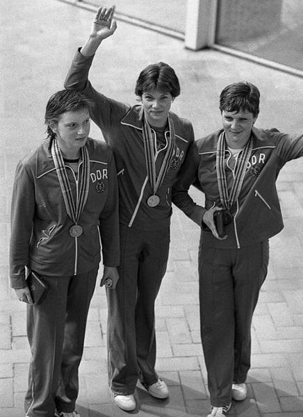 Olympiade in Moskau 1980, Siegerinnen über 200 Meter Rücken. Die Originalbeschreibung von ADN am 27.7.1980 lautete: „Moskau: Olympia/ Erneut dreifacher DDR-Erfolg/ Ihre dritte Goldmedaille holte sich Rica Reinisch (DDR/M.), die die 200 m Rücken in der neuen Weltrekordzeit von 2:11,77 min. vor Cornelia Polit (l./Silber) und Birgit Treiber (r./Bronze) für sich entschied. Die 15jährige Siegerin vom SV Einhait Dresden holte sich bereits mit der 4 x 100-m-Lagenstaffel und über 100 m Rücken Gold.” Foto: Wolfgang Kluge. Quelle: [http://commons.wikimedia.org/wiki/File:Bundesarchiv_Bild_183-W0727-138,_Moskau,_Olympiade,_Siegerinnen_%C3%BCber_200_m_R%C3%BCcken.jpg Bundesarchiv Bild 183-W0727-138 CC-BY-SA].