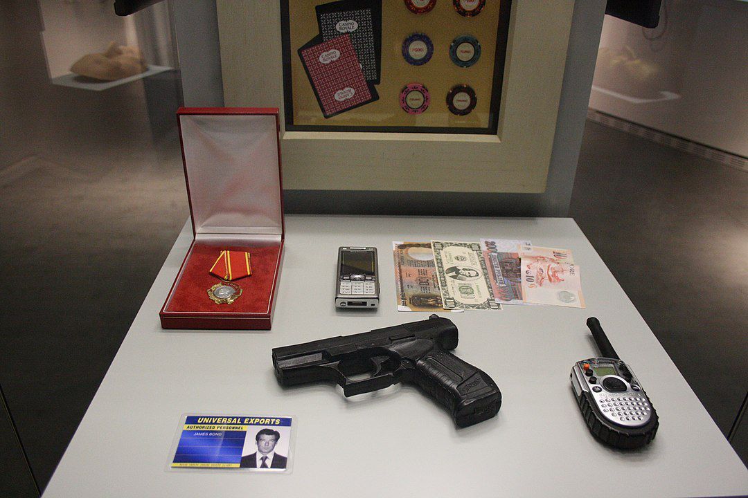 James Bond paraphernalia in the Berlin Spy Museum. The fictional agent James Bond, “007,” illustrates in a paradigmatic way the interrelationship between popular representations and intelligence practice. It is true that the Cold War is only hinted at as the historical background to Ian Fleming's James Bond novels and their film adaptations. Fleming’s experiences as a naval intelligence officer during World War II, helping to plan several special-forces operations behind enemy lines, are more obvious on the other hand. That perceptions of the fictional James Bond led political decision-makers to venture into risky waters is probably true in the case of John F. Kennedy. An avowed fan of Fleming with no intelligence experience of his own, Kennedy issued orders for the invasion of the Bay of Pigs in Cuba, an operation planned by the CIA but repudiated by military experts and which turned into a foreign-policy fiasco. Photo: Scontrofrontale, September 24, 2015, source: [https://commons.wikimedia.org/wiki/File:James_Bond_Requisiten.JPG#/media/File:James_Bond_Requisiten.JPG Wikimedia Commons], License: [https://creativecommons.org/licenses/by-sa/4.0/ CC BY-SA 4.0]