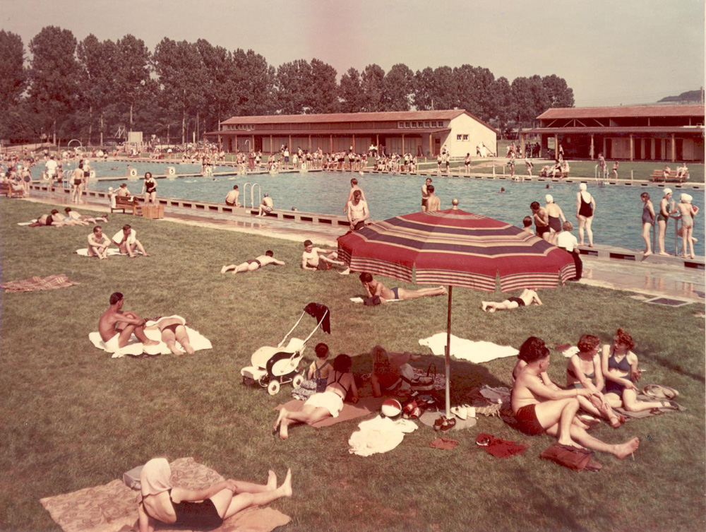Farbfoto eines Freibads mit vielen Menschen