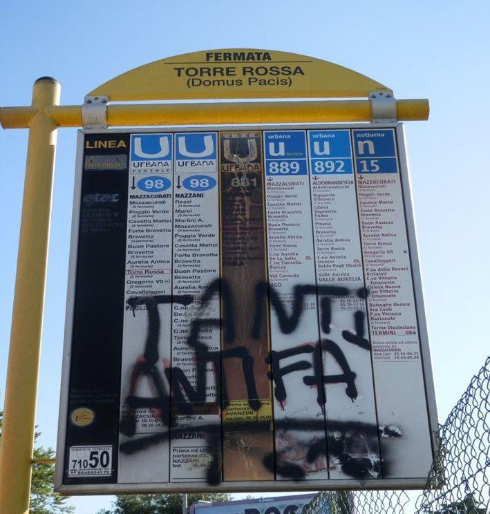 Gelbes Schild der Torre Rossa Busa´haltestelle. Besprüht mit dem Schriftzug Tanti Antifa