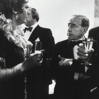 Eine gut gekleidete Frau und ein Mann mit Sektgläsern