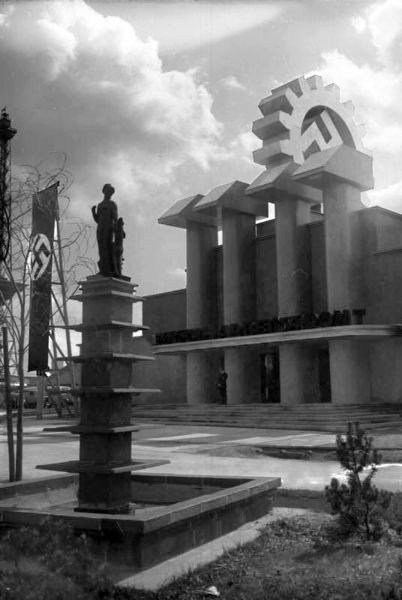 Schwarz-Weiß-Fotografie eines Monuments aus großen Hammern und einem Zahnrad mit einem Hakenkreuz in der Mitte.